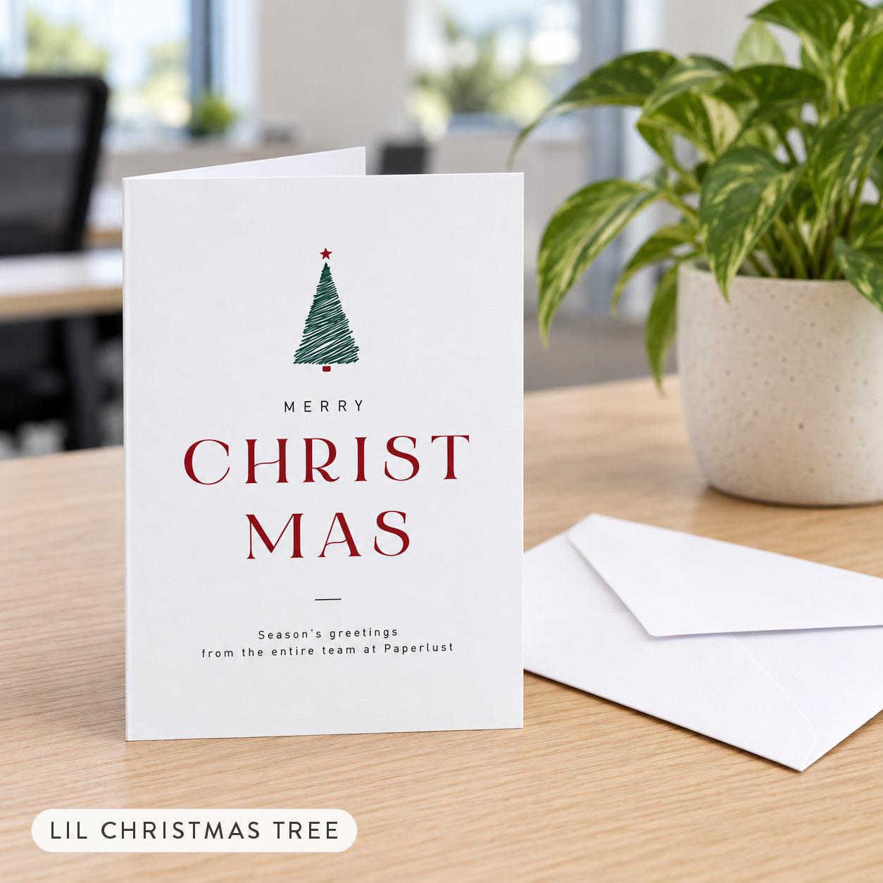 Lil Christmas Tree folded A6 corporate Christmas card standing on an office desk beside its envelope