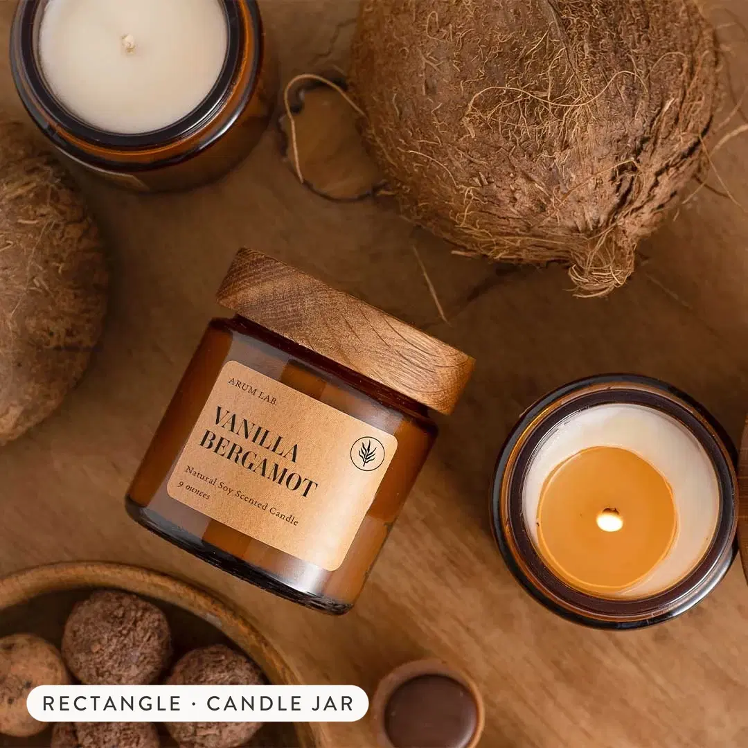 Custom vinyl labels on amber candle jars, printed on waterproof white synthetic film