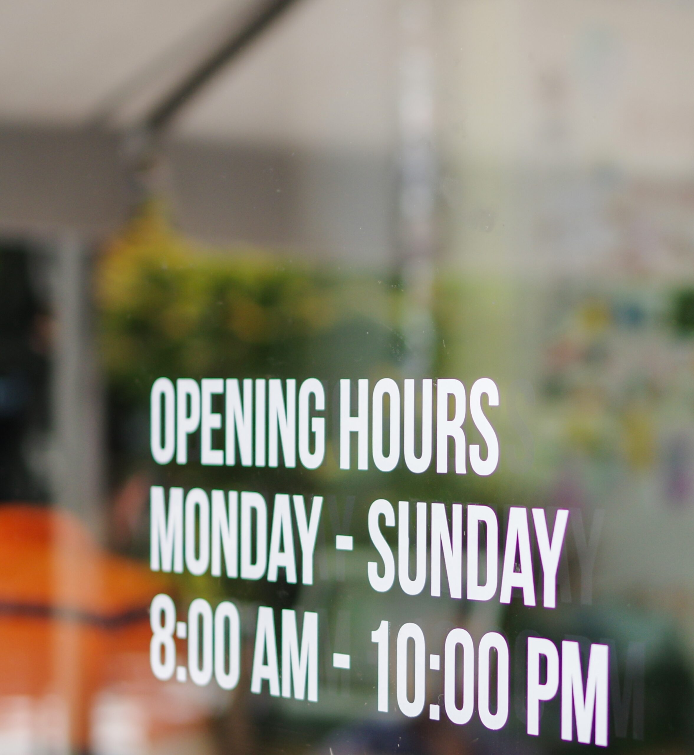 Opening hours window decal applied to retail storefront