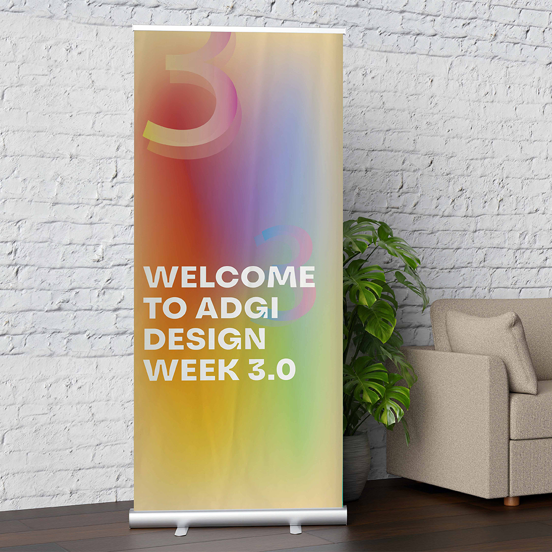 a premium pull up banner on its retractable cassette base displaying a printed event welcome graphic against a white brick wall