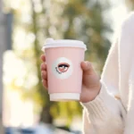 Circle sticker with brand logo on takeaway coffee cup