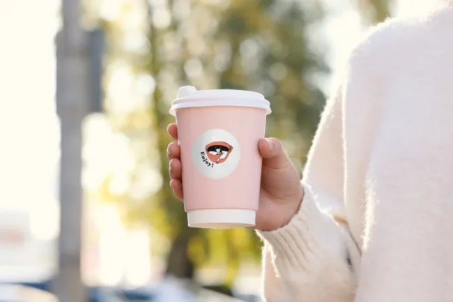 Circle sticker with brand logo on takeaway coffee cup