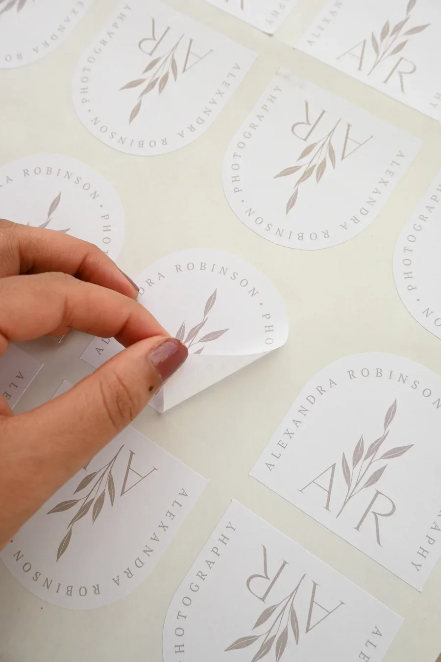Custom sticker peeling cleanly off plastic surface: quality adhesive demonstration.