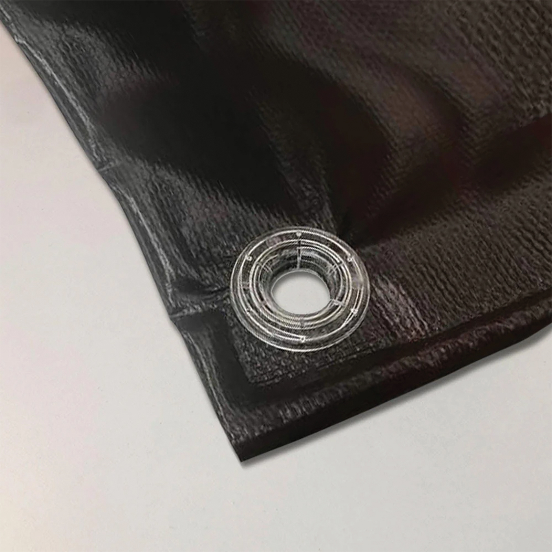 Close-up of a vinyl banner's hemmed edge and reinforced clear eyelet used for fixing