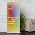 Pull-up banner displaying a welcome message, retractable banner stand set up indoors at an event