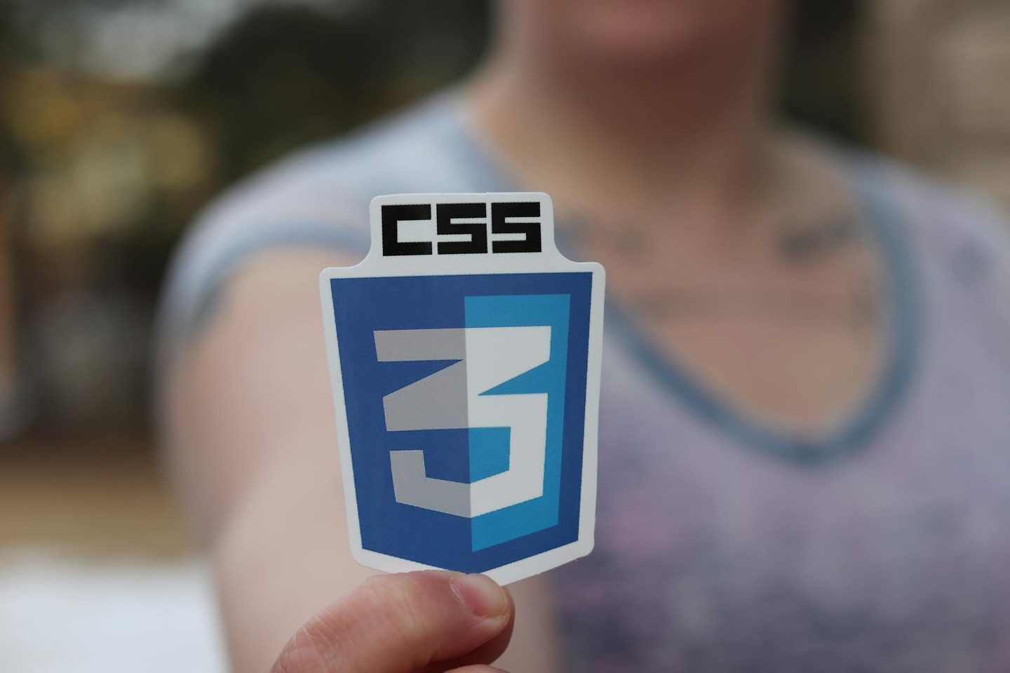 A4 custom sticker sheet being placed inside a branded e-commerce shipping satchel as a packaging insert, showing the full sheet next to tiss