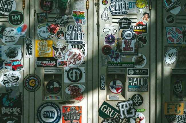 Assortment of custom sticker sheets spread on a retail surface showing multiple themed designs on A4 and A5 sheet formats