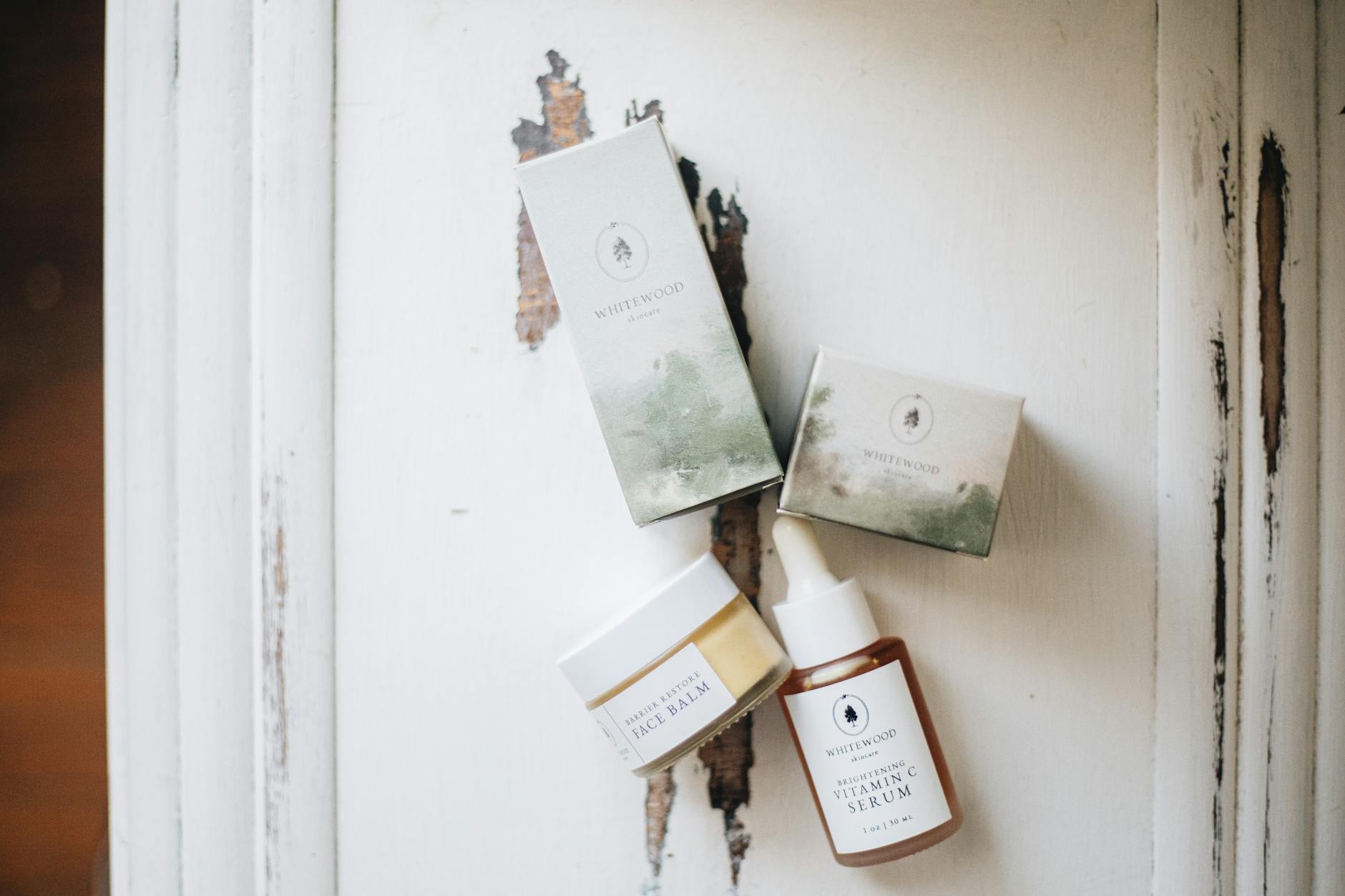 Flat-lay showing three product types side by side, a clear glass jam jar, a matte black kraft mailer box, and a clear plastic food pouch, al