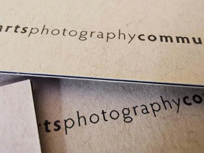 Side-by-side comparison of three consultant business card finishes on a neutral surface: a standard matte card with navy typography, a spot