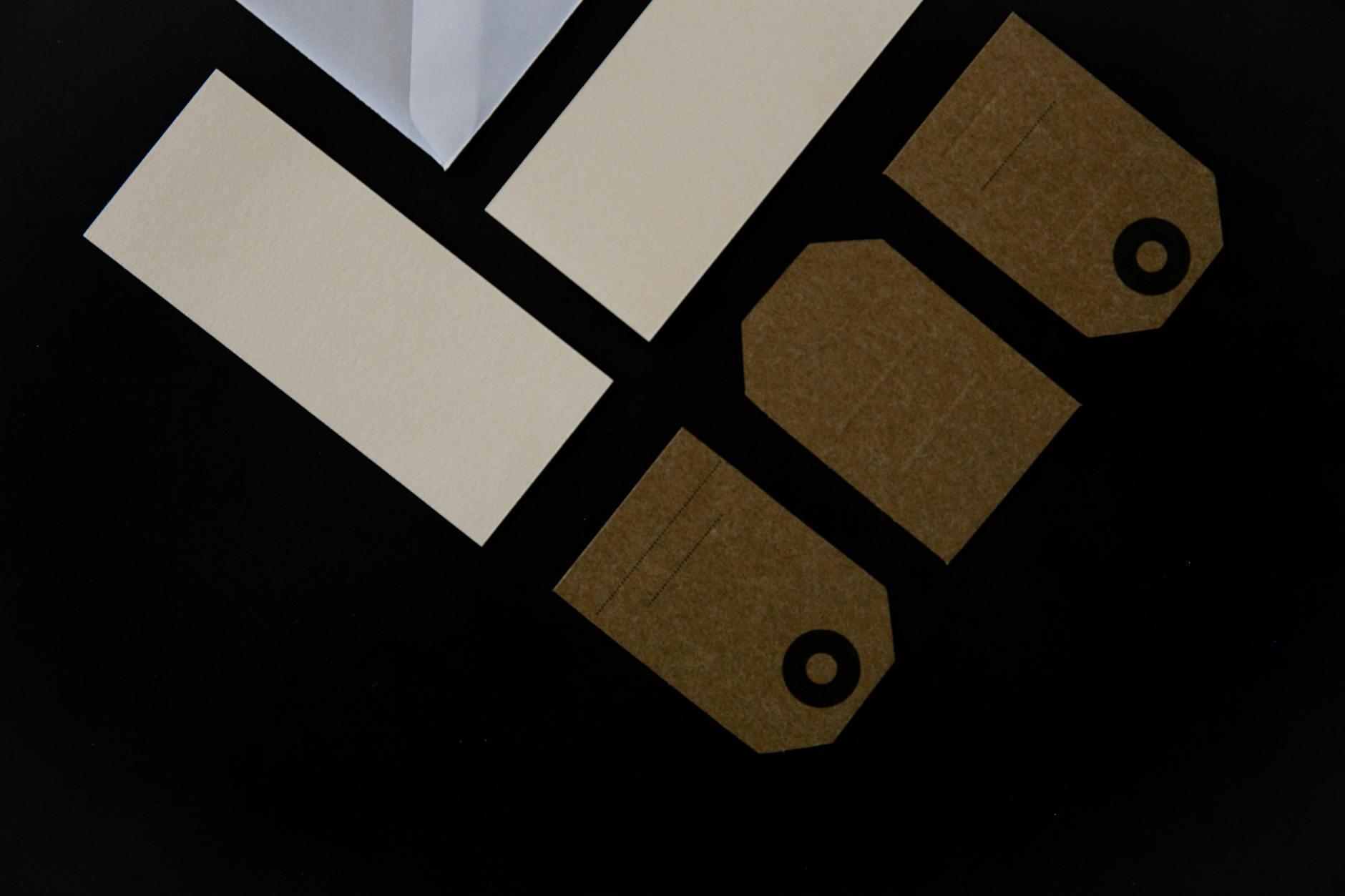 flat-lay of three custom-shaped die-cut business cards on a timber surface - a house silhouette for real estate, a coffee cup outline for a