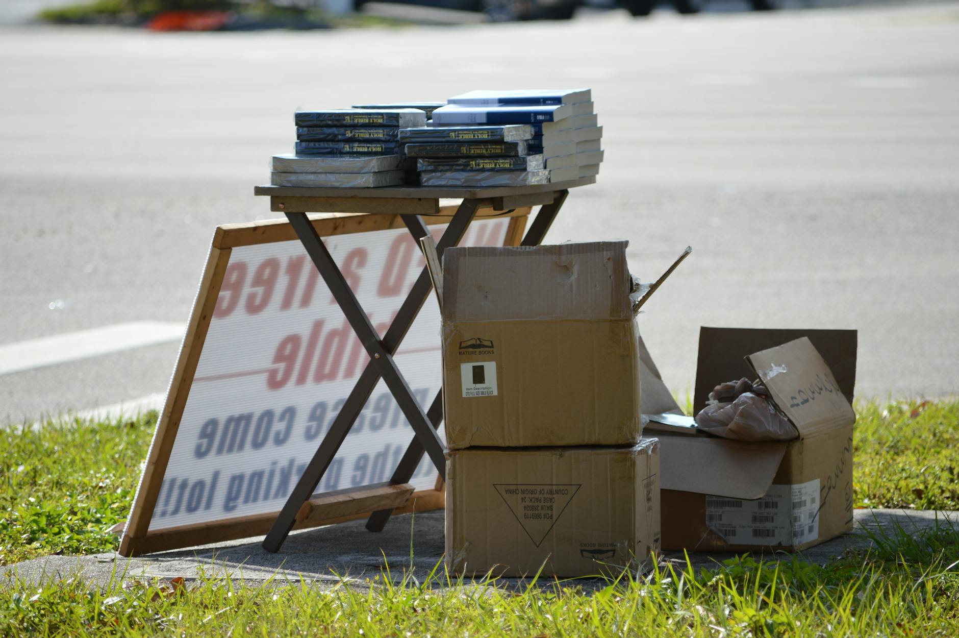 Stack of freshly printed corflute election signs viewed from a slight angle, showing vivid full-colour printing, board thickness visible on