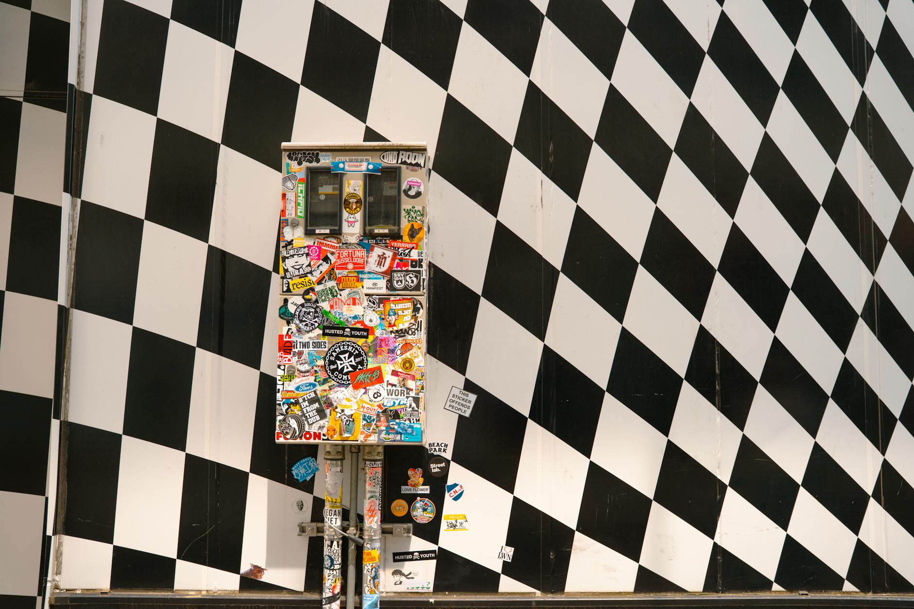 permission sticker wall at an outdoor Australian street market covered in colourful layered brand stickers