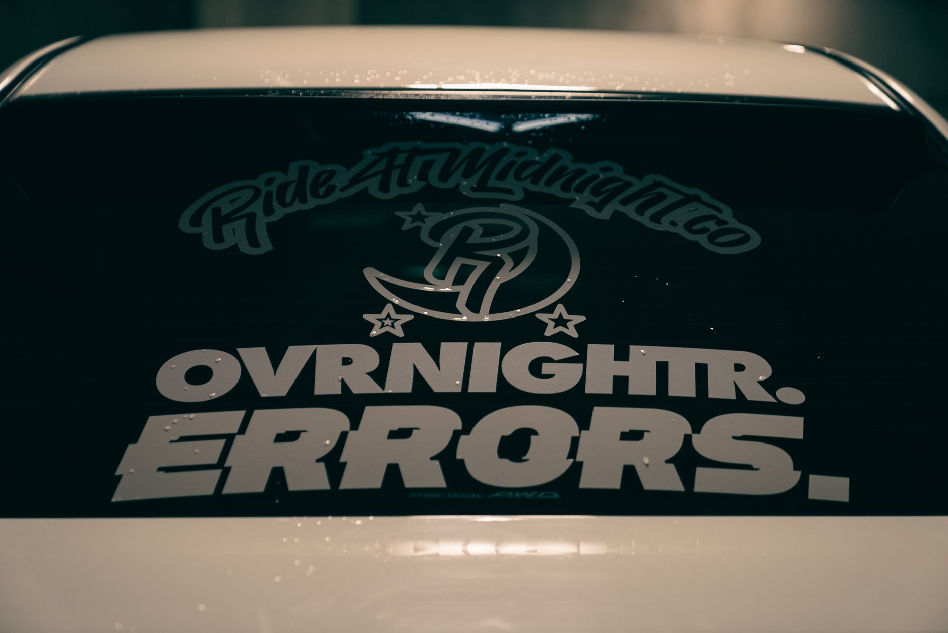 branded vinyl bumper sticker on the back of a white delivery van driving through an Australian urban street