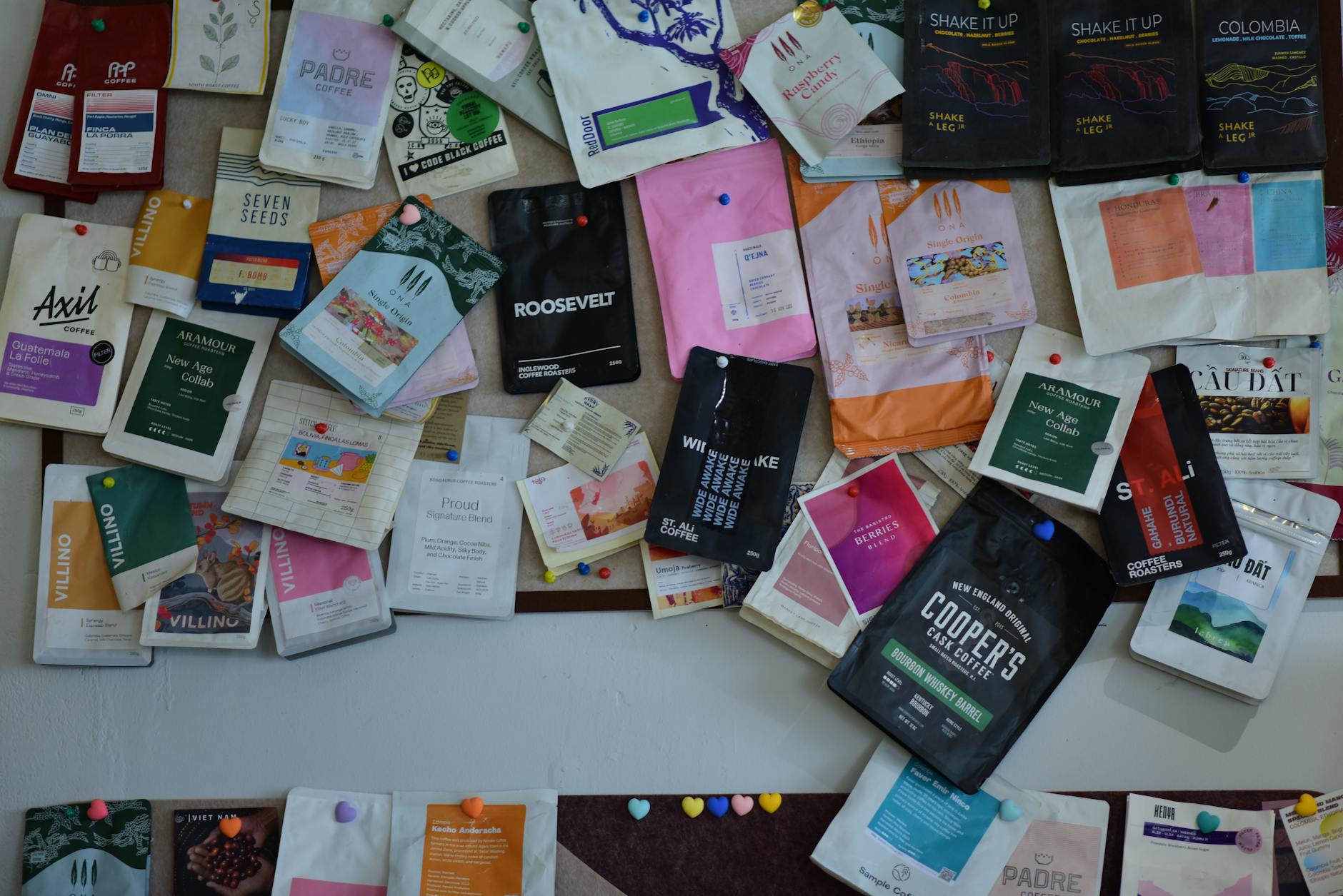 A flat-lay of a variety of branded stickers in different finishes including holographic foil, clear, and matte vinyl arranged on a light tim