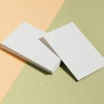 Detail shot of a Spot UV business card showing a glossy logo and brand name contrasting sharply against a matte base, photographed in angled