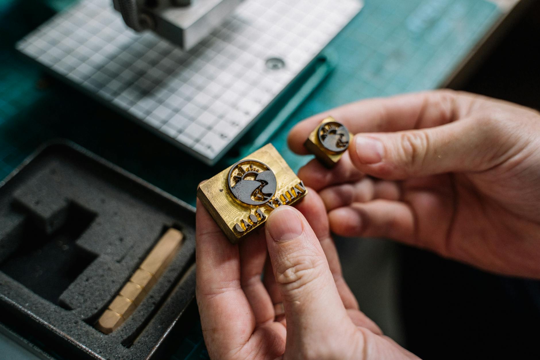 business card printing process showing foil stamping on dark cardstock, gold foil detail being applied