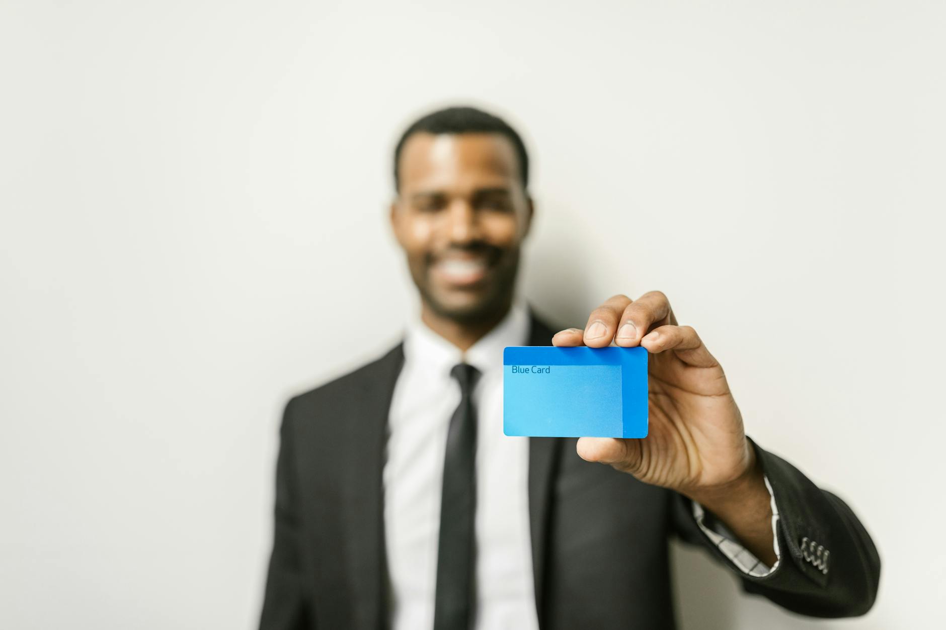 business professional handing a premium business card to another person in a modern office setting, warm natural light