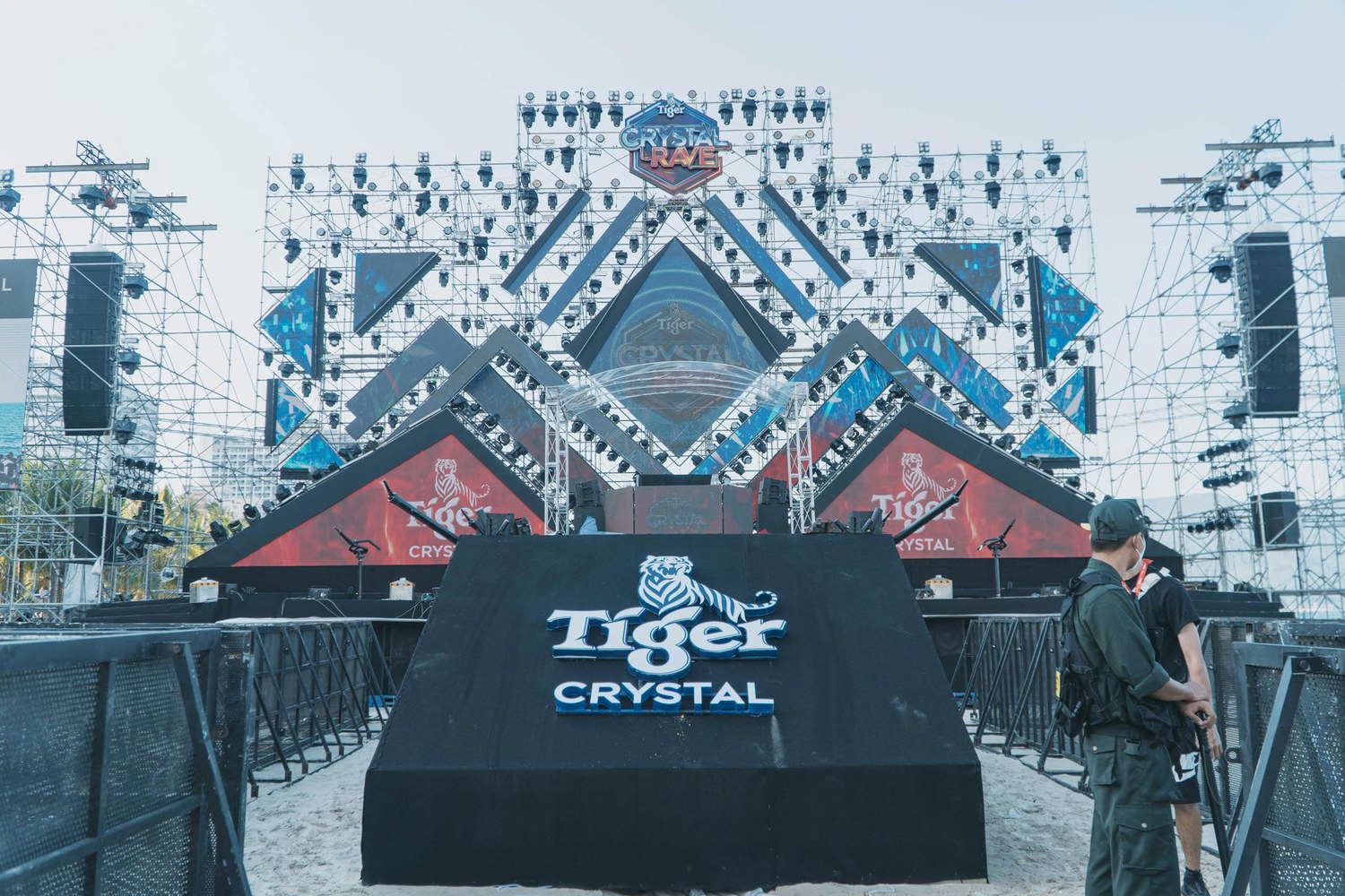 Outdoor brand launch event with a bold geometric stage design and Tiger Crystal branding printed on the central media wall podium.