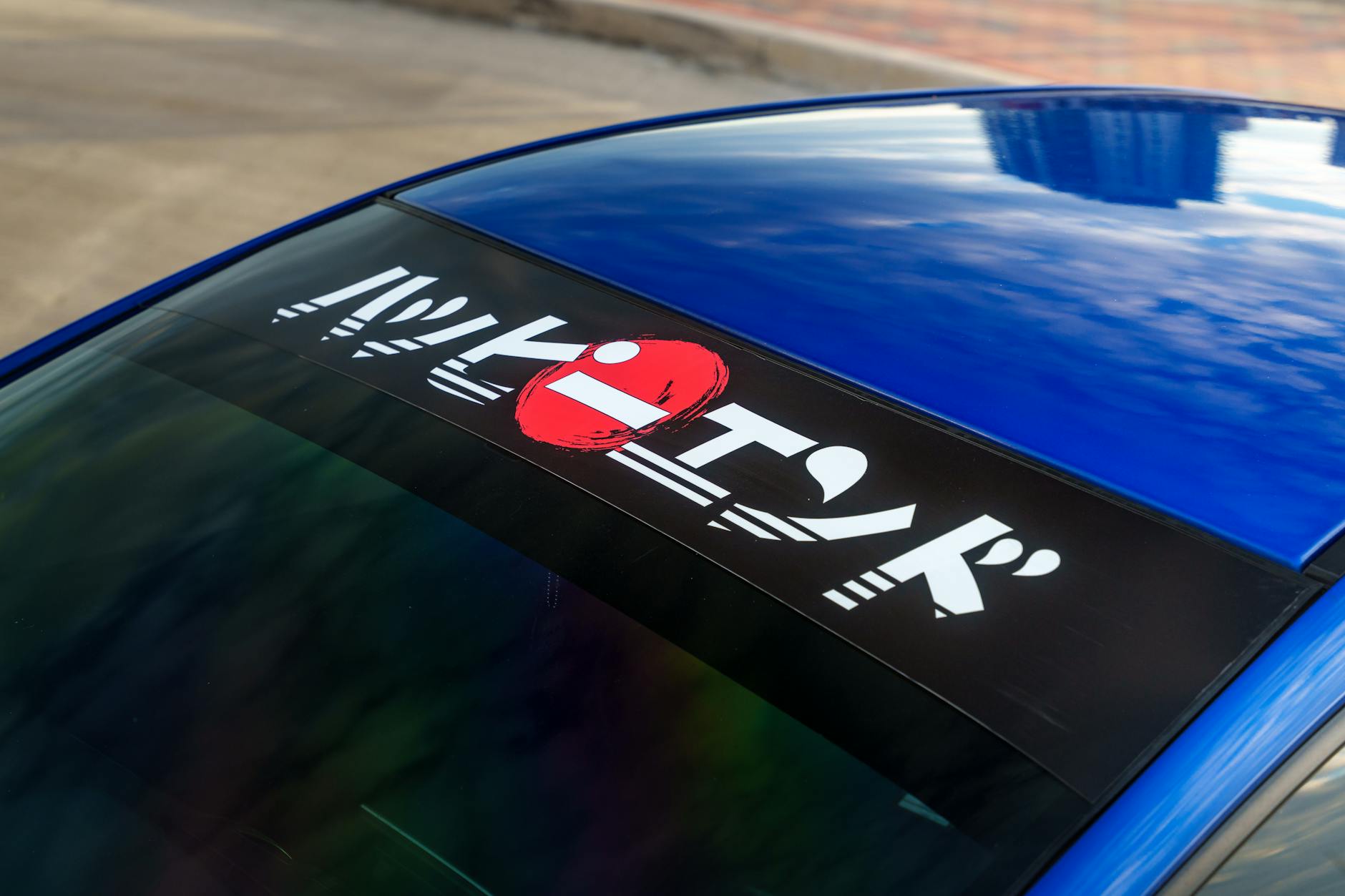 Custom reflective sticker with printed business logo and contact phone number applied to the door panel of a white tradesperson's ute photog