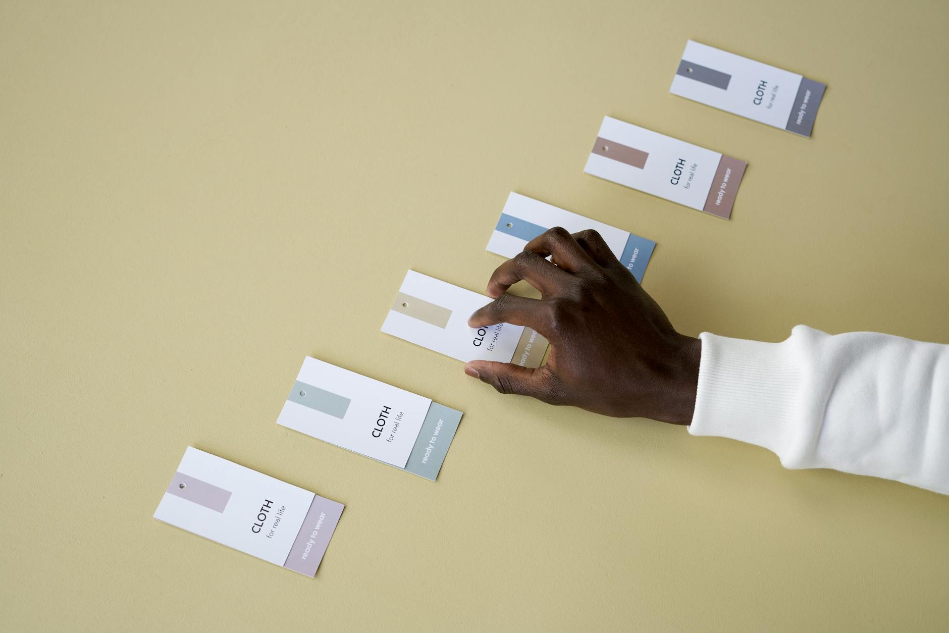 A flat lay of business card samples in different finishes, including standard matte, coloured paper in deep navy, and spot UV with gloss log
