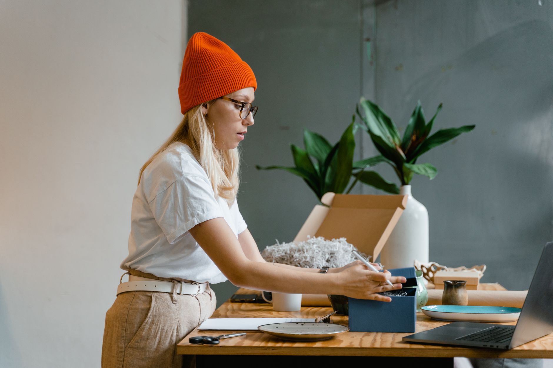 Australian small business owner reviewing a freshly printed sticker sheet order at a timber desk, examining colour accuracy with a brand swa