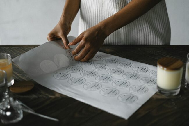 a business sticker sheet with multiple brand designs visible - circular seals, rectangular product labels and logo die-cut stickers in brand