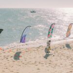 Teardrop banner outdoor event setup, large branded flag on ground spike at a corporate expo or sports event, daytime, outdoor setting