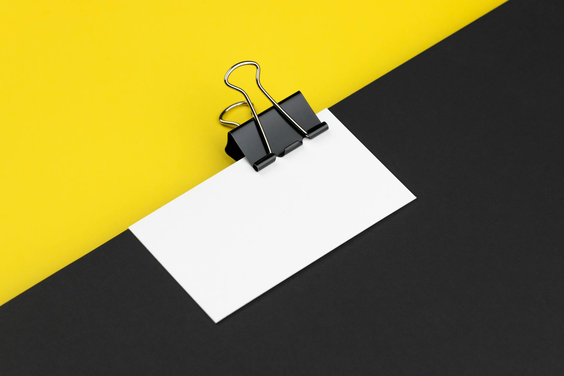 close-up macro photograph of a vertical business card with raised foil name treatment catching the light against a dark matte surface