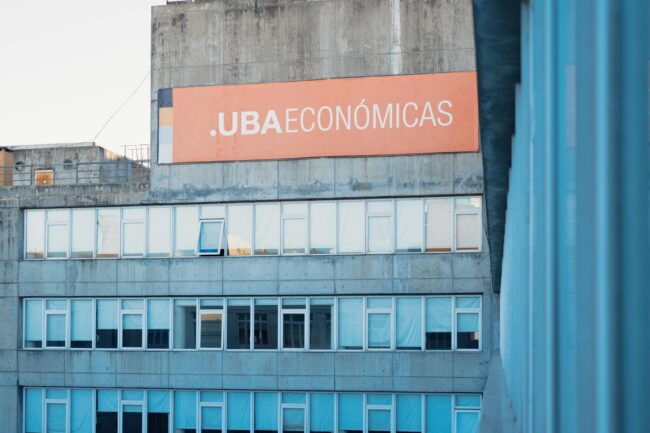 Wide-format vinyl banner mounted on a commercial building facade, vivid full-colour print, outdoor setting, storefront or construction hoard