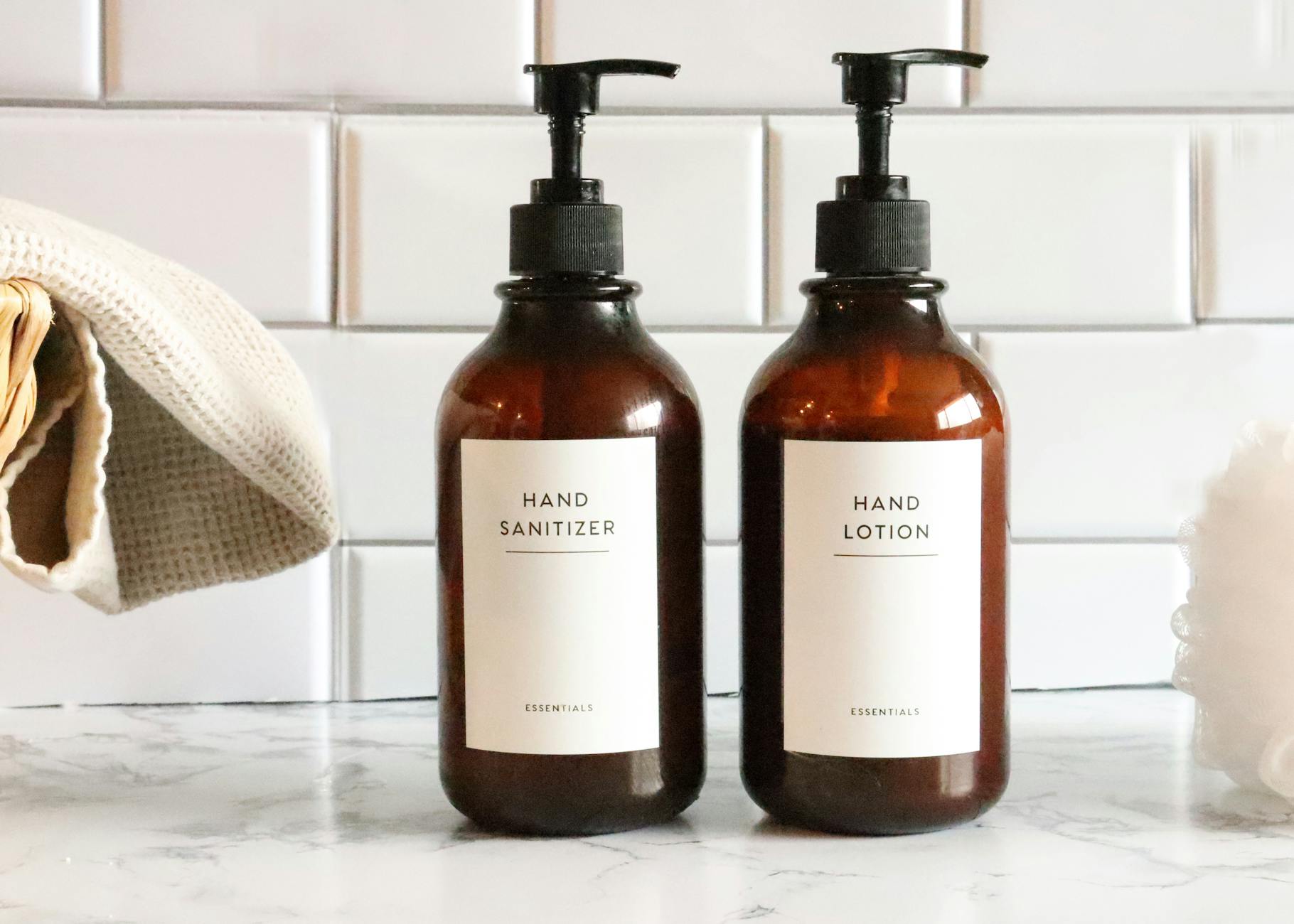 tidy bathroom shelf with matching label sets on white storage containers, printed vinyl sticker sheet visible in the background showing the
