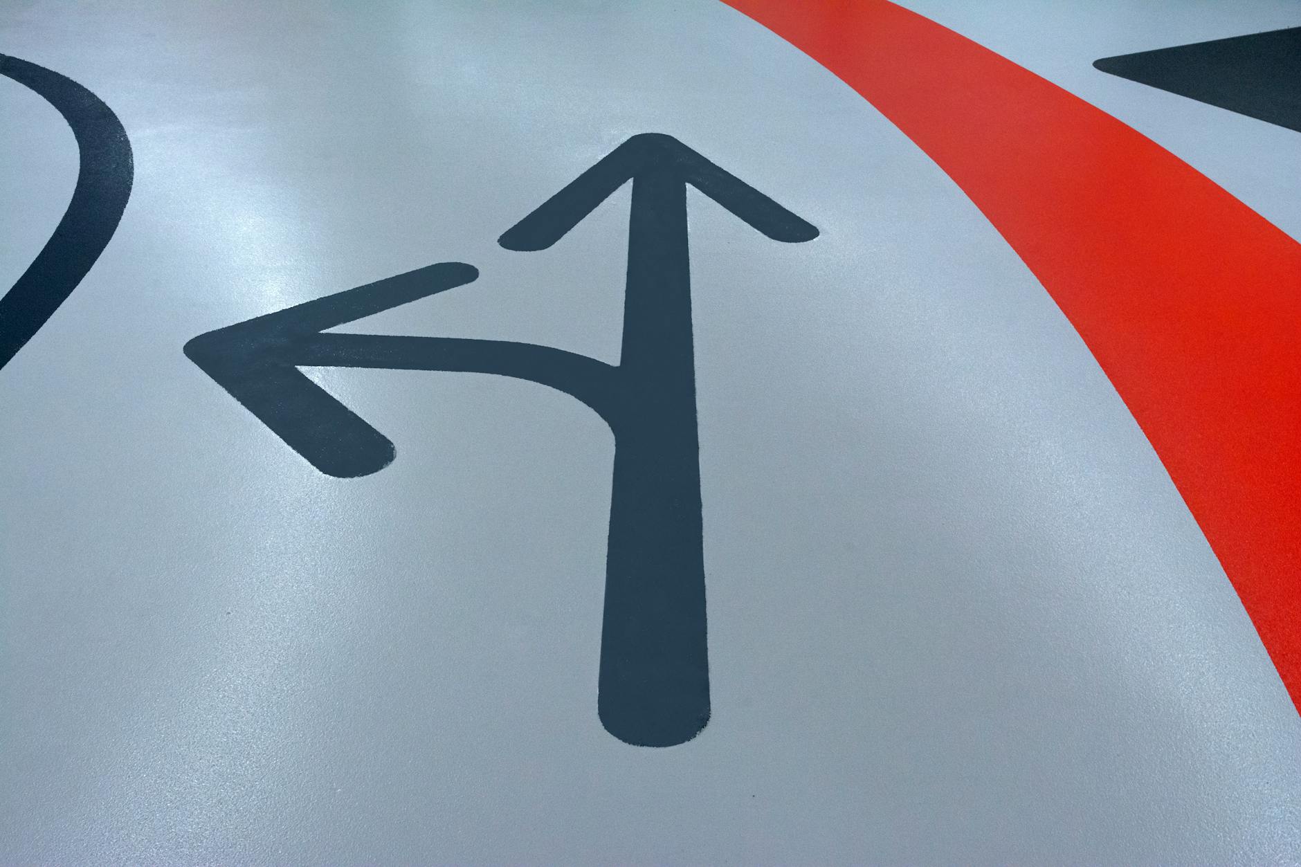 Close-up of a wayfinding sign with clear sans-serif text and directional arrows showing good contrast, legibility, and consistent design lan