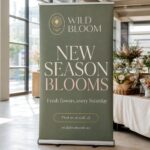 A tall trade-show pull-up banner with a bold, legible headline at a clean exhibition booth, designed to be read from five metres away.