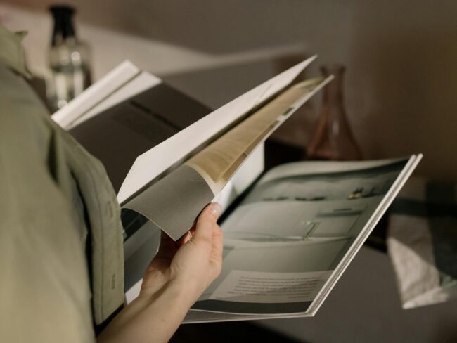 A stack of professionally printed saddle-stitched booklets with laminated covers.