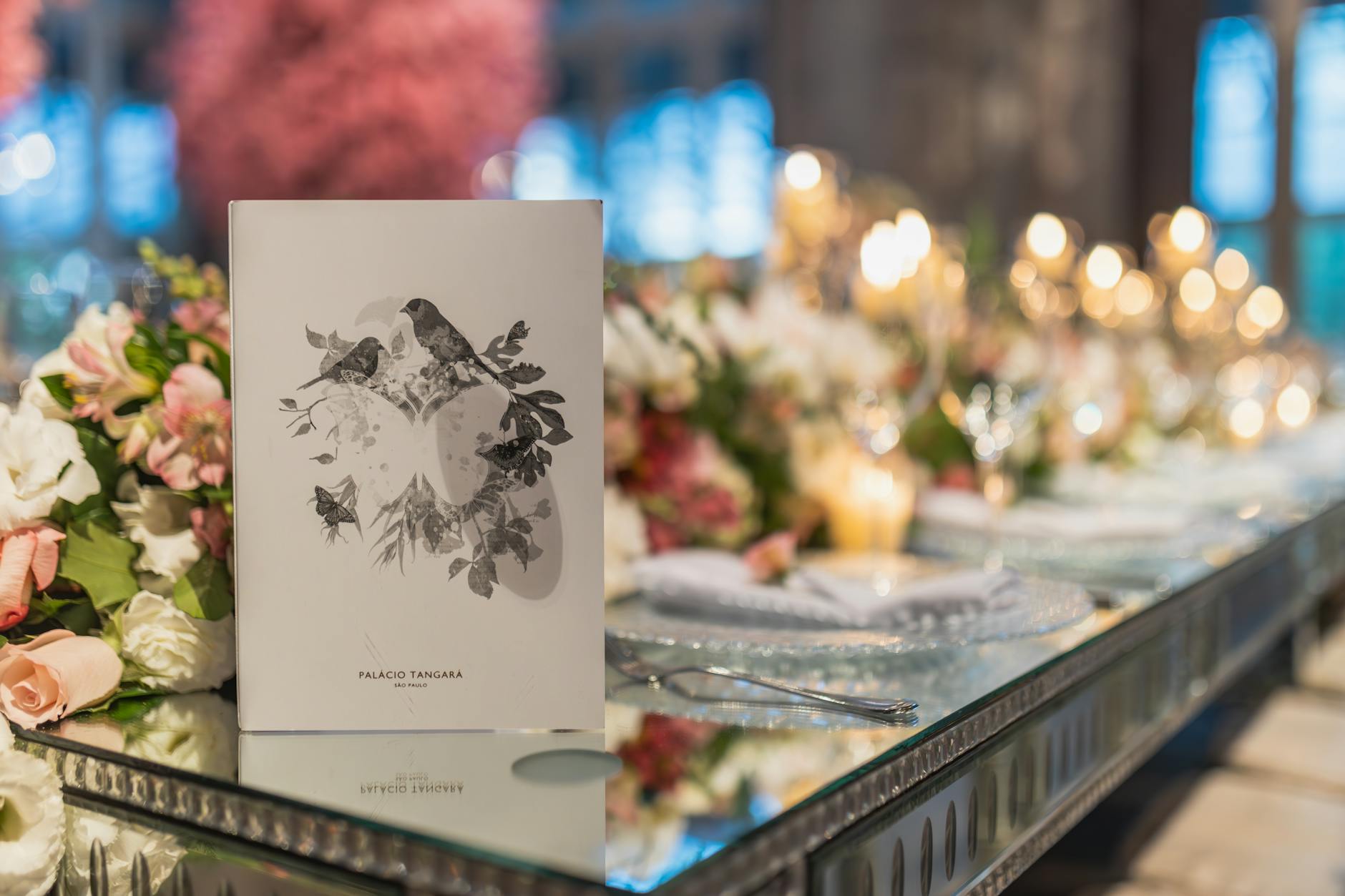 An A5 event program printed with a matt laminated cover, open on a table at a styled venue, alongside folded order-of-service cards