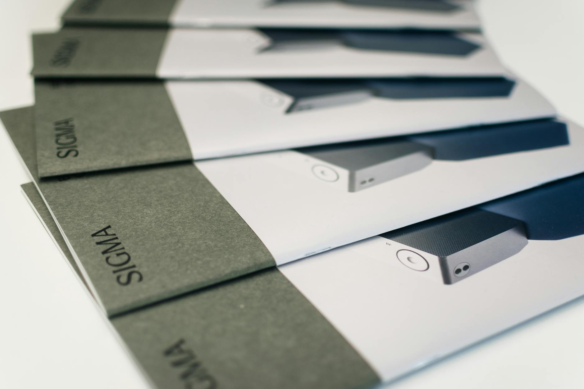 A spread of three finished brochures side by side on a light desk surface, showing A5 bi-fold open, DL tri-fold open, and DL Z-fold open