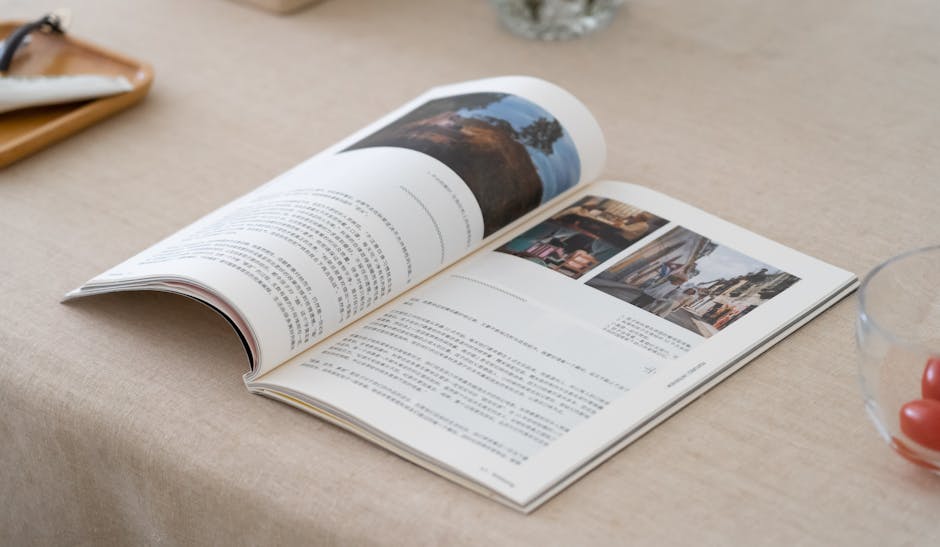An open printed booklet showing a two-page spread of text and photographs on a table
