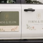 A lifting magnetic sign beside a flush vinyl decal on a vehicle door, comparing magnetic vehicle signs versus vinyl decals.