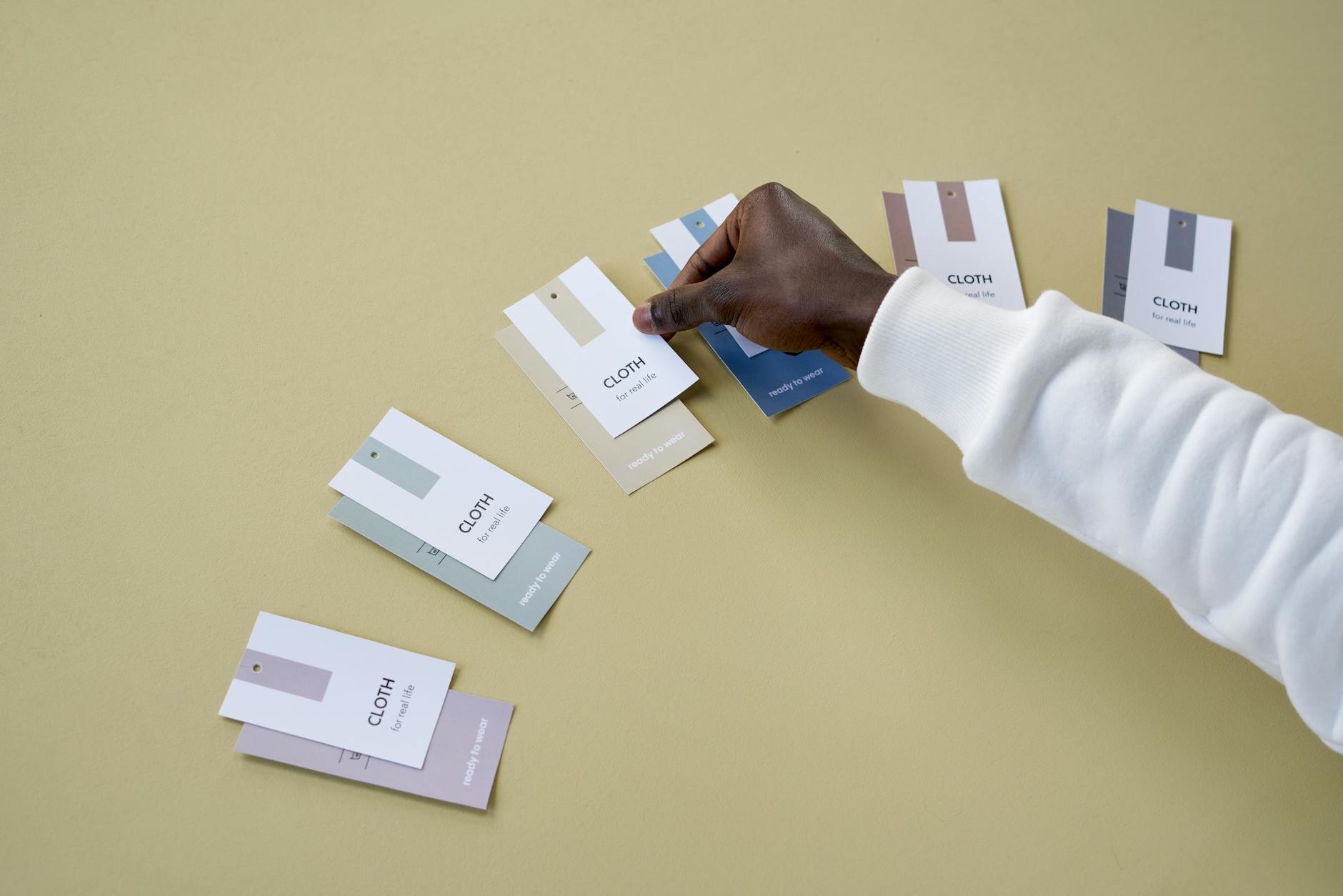 Flat lay of a label artwork file on a screen next to printed label samples showing bleed marks, dieline, and final trimmed result, square