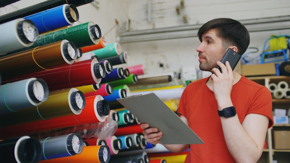 Print shop worker beside colourful rolls of vinyl sticker material