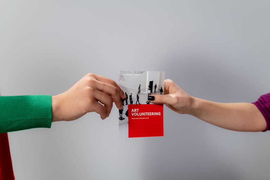 Two people exchanging a printed promotional flyer by hand