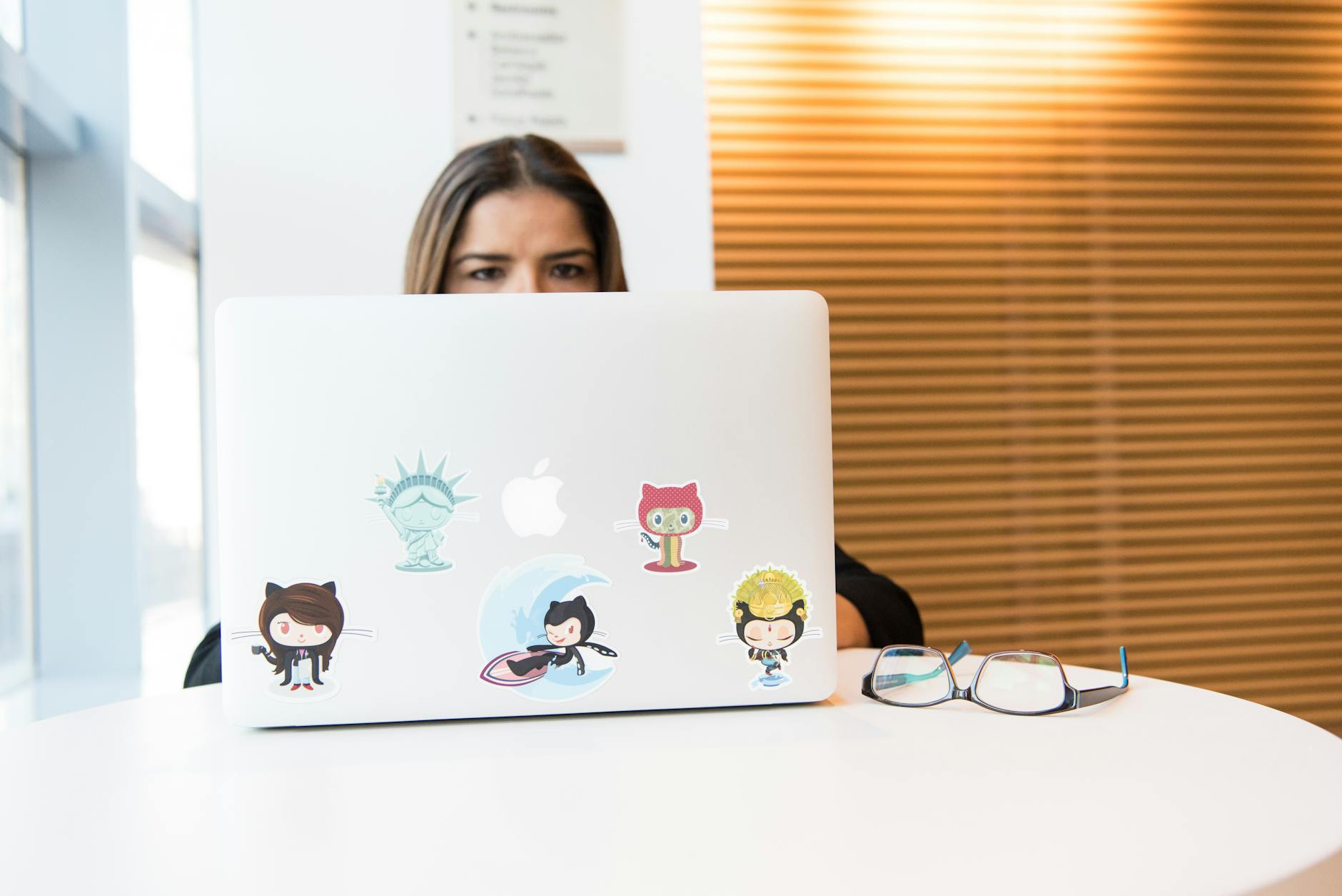 die-cut custom vinyl stickers applied to a laptop lid, showing varied colourful printed designs with clean cut edges