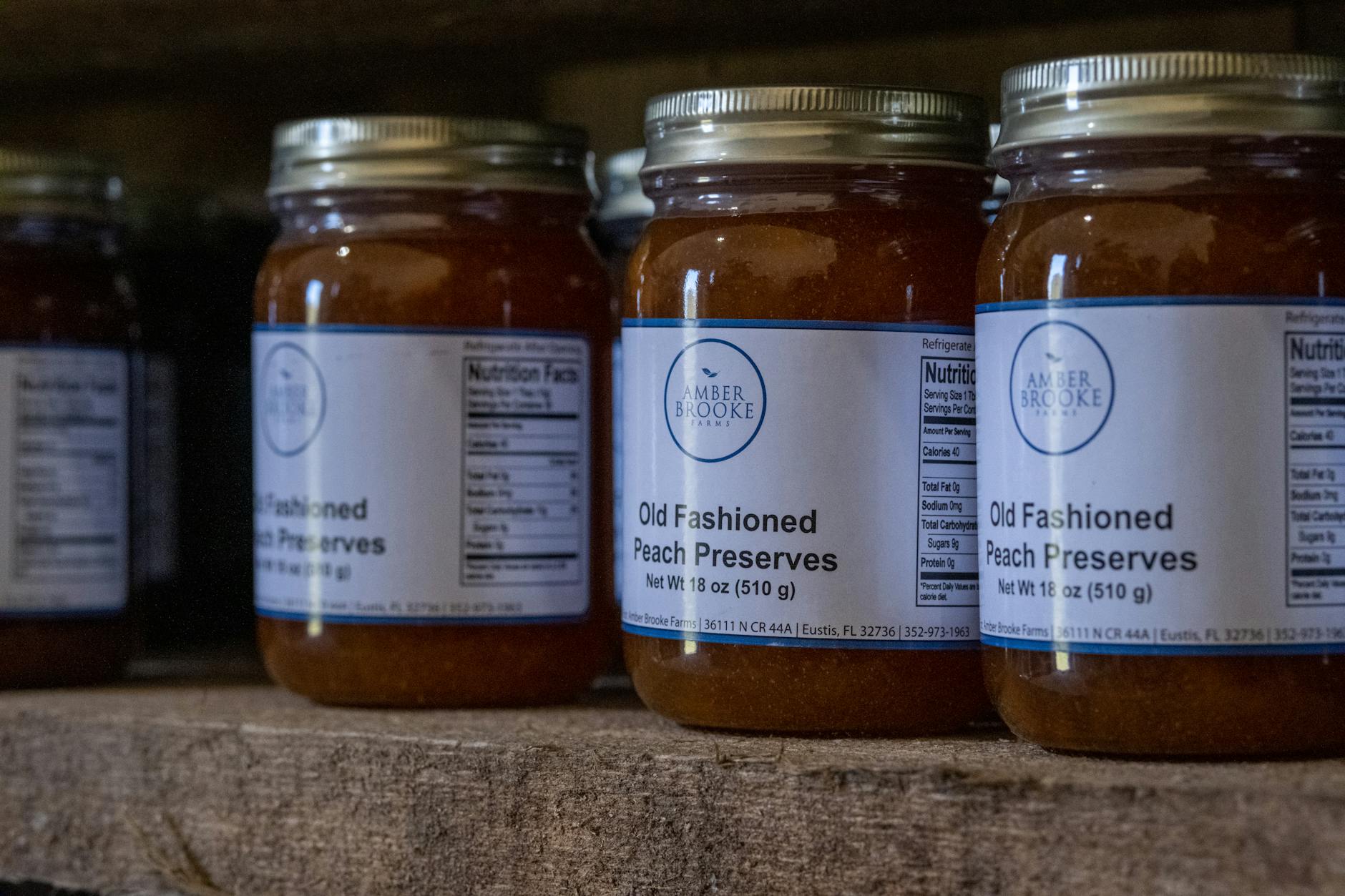 Assortment of oval, rectangle and circle label shapes applied to a lineup of glass jars containing herbs, honey and a candle, on a white