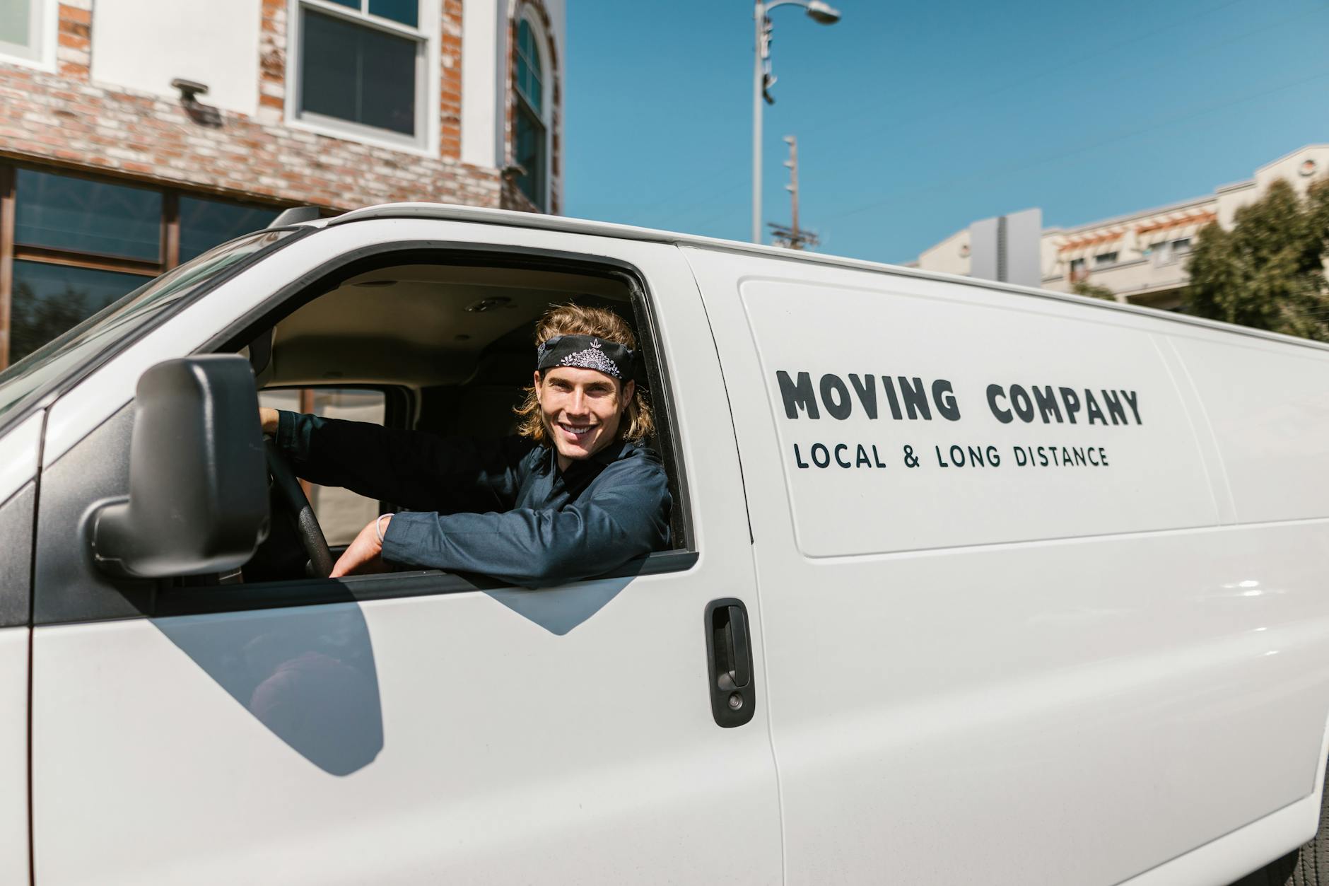 Side-by-side of two identical white vans, one with professionally installed vinyl decals wrapping the door and rear panel, the other with a