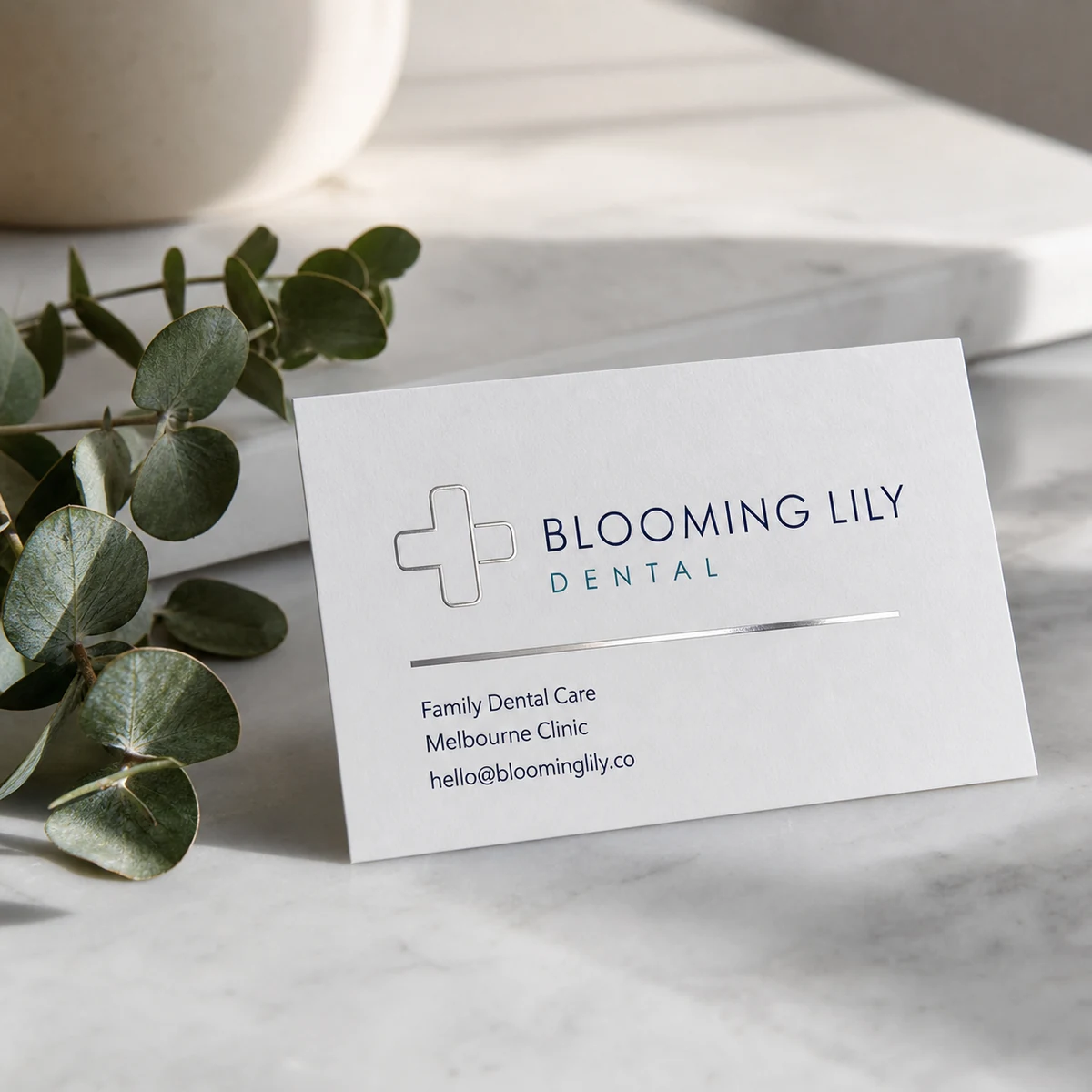Dental clinic business card, white · 350gsm matte stock · full-colour digital print · satin laminate with silver flat foil