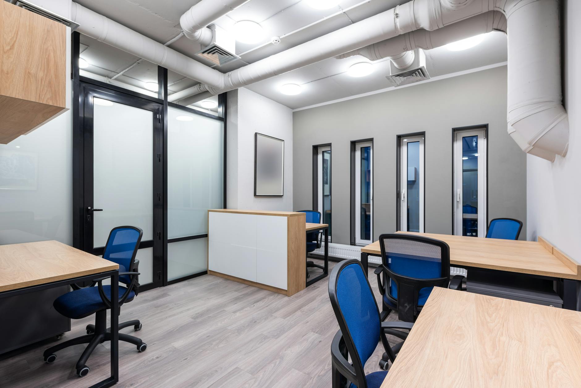 Modern commercial office reception area showing frosted decal on lower glass partition panel with clear company logo cutout, contemporary