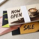 Neat banded bundle of rectangular small-business marketing postcards on a neutral surface, ready for a direct mail campaign.