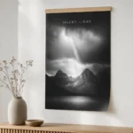 An A2 black-and-white photographic poster on 200gsm synthetic stock hung flat from a timber hanger on a white wall, rich shadow detail, flexible paper lying flat with no curl, not canvas or framed