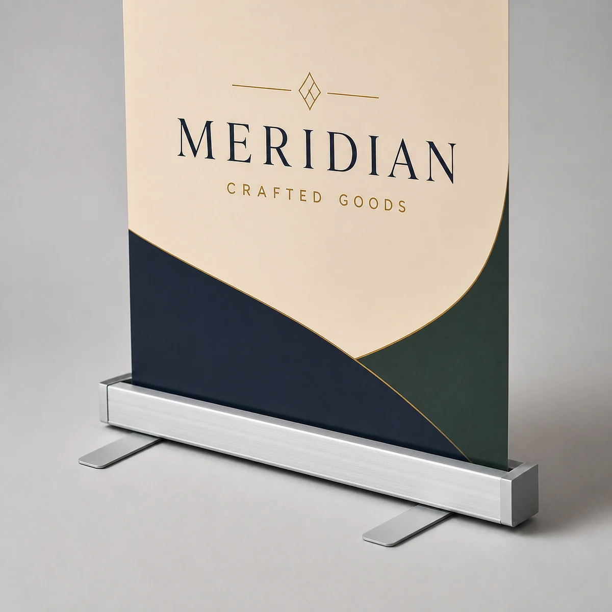 Close-up of a premium retractable banner's printed vinyl panel rising from a slim flat brushed-aluminium cassette base with exactly two forward paddle feet, sharp text and bold brand colours