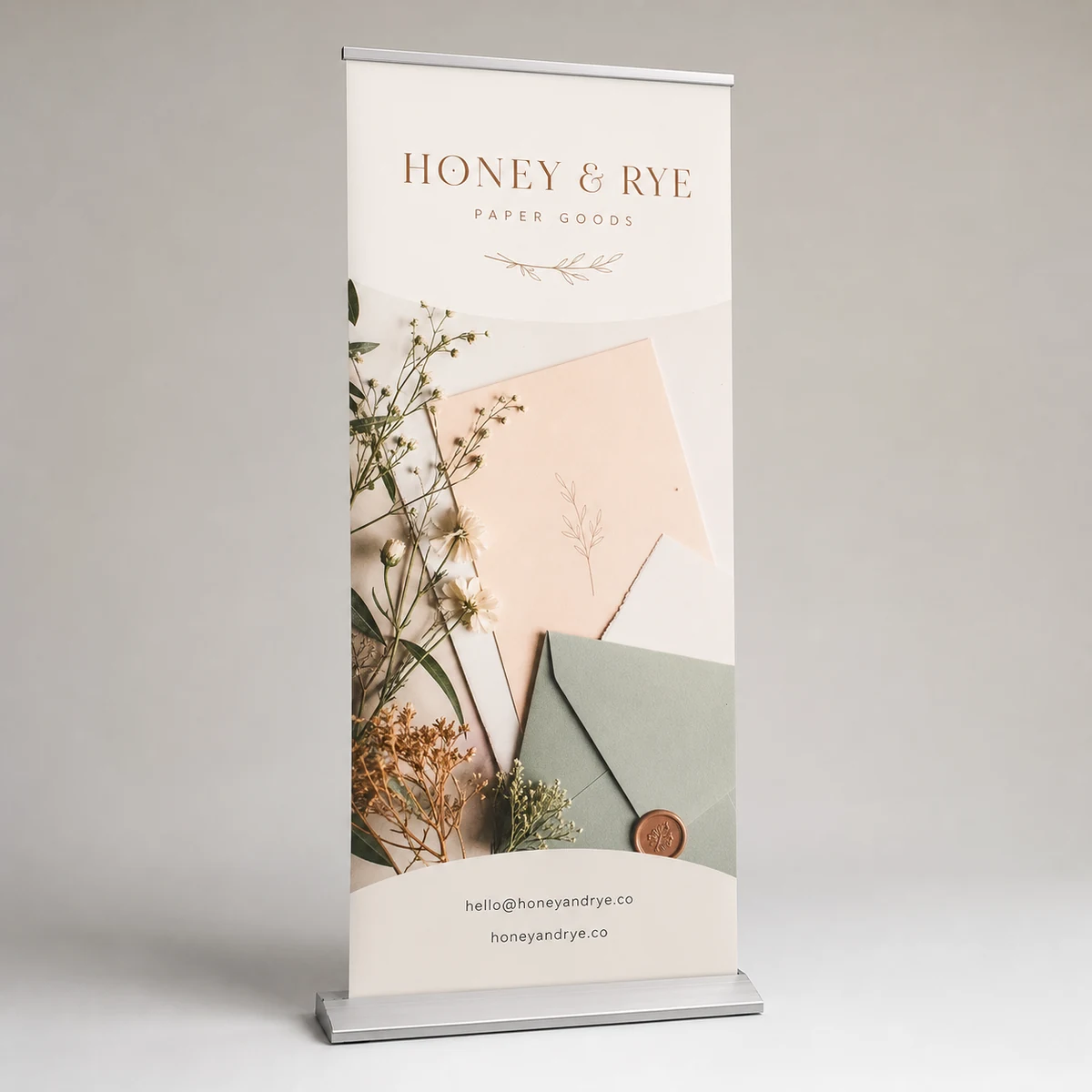 A wide product shot of a full 850mm-wide premium retractable pull-up banner against a light studio backdrop, the whole panel from the slim flat aluminium cassette base to the top