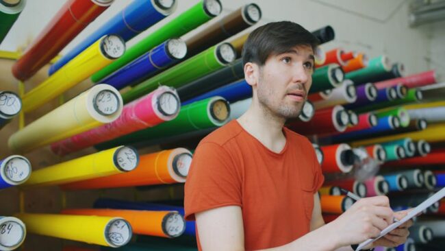 Colourful rolls of vinyl sticker material in a print workshop